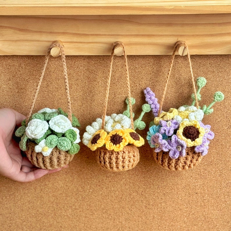 Crocheted hanging plant pots with colorful flowers on a wooden shelf